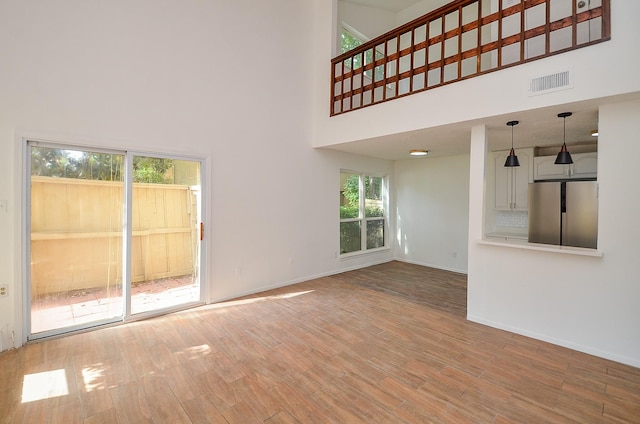 3538 Ocee St, Houston, TX 77063 - unfurnished living room with a high ceiling, wood finished floors, and baseboards