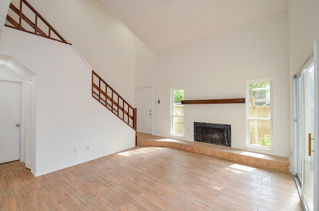 3538 Ocee St, Houston, TX 77063 - unfurnished living room with high vaulted ceiling, wood finished floors, plenty of natural light, stairs, and a tiled fireplace