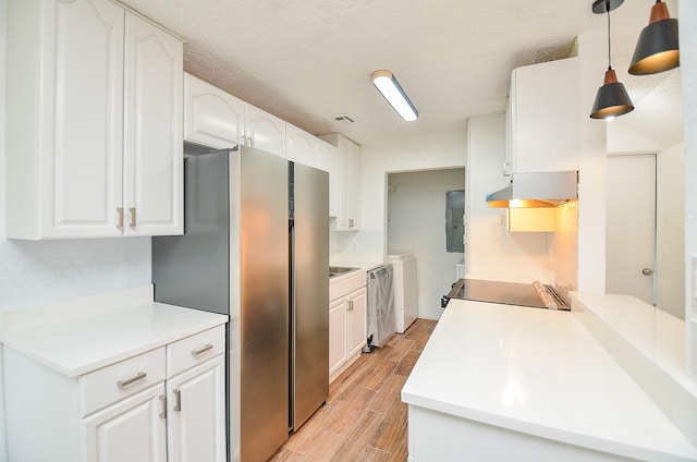 3538 Ocee St, Houston, TX 77063 - kitchen with wood finish floors, under cabinet range hood, separate washer and dryer, stainless steel appliances, and white cabinetry