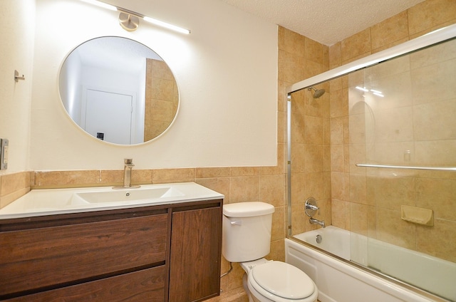 3538 Ocee St, Houston, TX 77063 - bathroom with vanity, toilet, tile walls, a wainscoted wall, and combined bath / shower with glass door