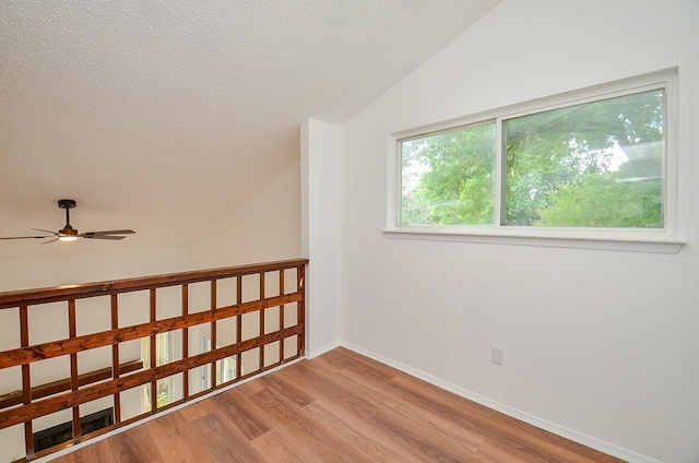 3538 Ocee St, Houston, TX 77063 - empty room featuring wood finished floors, a ceiling fan, vaulted ceiling, a textured ceiling, and baseboards