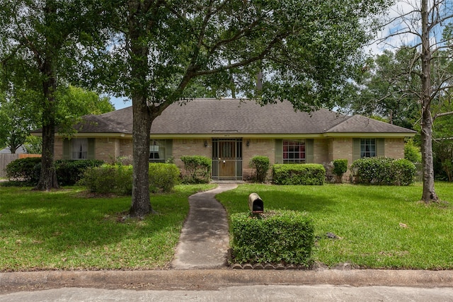 2812 Fairway Dr, Orange, TX 77630 - view of front of house with brick siding, a front yard, and a shingled roof