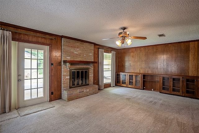 2812 Fairway Dr, Orange, TX 77630 - unfurnished living room with wooden walls, carpet floors, a textured ceiling, ceiling fan, and crown molding