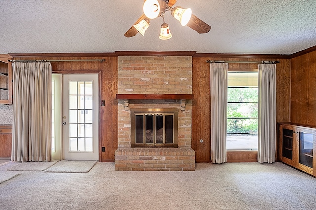 2812 Fairway Dr, Orange, TX 77630 - unfurnished living room with wood walls, a ceiling fan, ornamental molding, carpet, and a brick fireplace