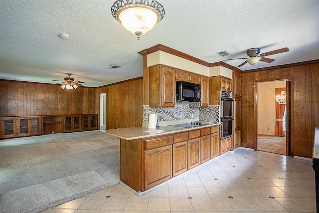 2812 Fairway Dr, Orange, TX 77630 - kitchen featuring black appliances, a ceiling fan, wood walls, brown cabinetry, and light countertops