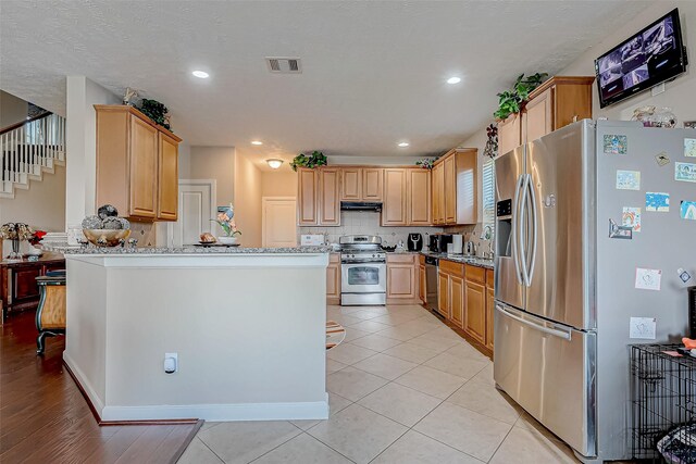 3619 Canton Hills Ln, Missouri City, TX 77459 - kitchen featuring appliances with stainless steel finishes, a peninsula, under cabinet range hood, tasteful backsplash, and recessed lighting