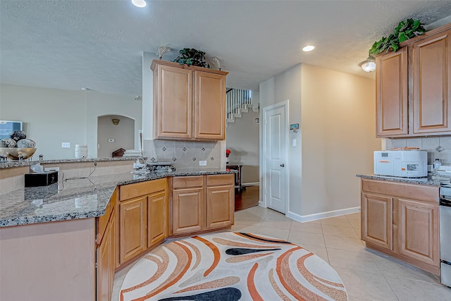 3619 Canton Hills Ln, Missouri City, TX 77459 - kitchen featuring arched walkways, tasteful backsplash, light tile patterned floors, stone counters, and recessed lighting