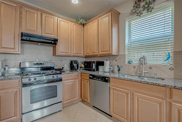 3619 Canton Hills Ln, Missouri City, TX 77459 - kitchen with stainless steel appliances, a sink, under cabinet range hood, tasteful backsplash, and light tile patterned floors