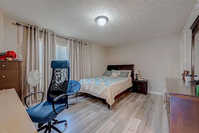 3619 Canton Hills Ln, Missouri City, TX 77459 - bedroom featuring light wood-type flooring, a textured ceiling, an office area, and baseboards