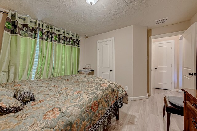 3619 Canton Hills Ln, Missouri City, TX 77459 - bedroom with light wood finished floors, baseboards, and a textured ceiling