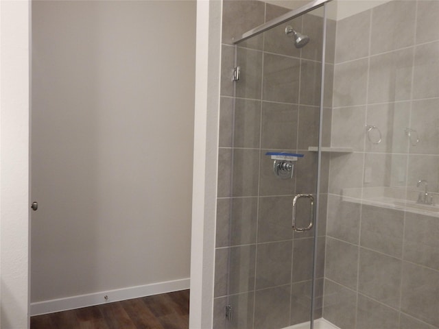 228 Rustic Ridge Cir, Magnolia, TX 77354 - bathroom featuring a stall shower, wood finished floors, and baseboards