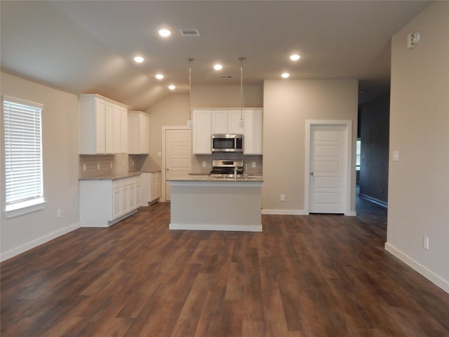 228 Rustic Ridge Cir, Magnolia, TX 77354 - kitchen with appliances with stainless steel finishes, decorative backsplash, a center island with sink, white cabinets, and recessed lighting