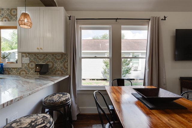 1127 Nadine St, Houston, TX 77009 - kitchen featuring healthy amount of natural light, dark wood-type flooring, tasteful backsplash, and white cabinets