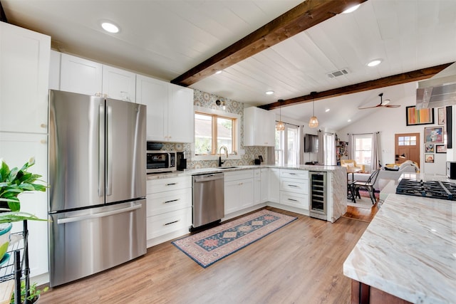 1127 Nadine St, Houston, TX 77009 - kitchen featuring appliances with stainless steel finishes, wine cooler, a peninsula, light wood finished floors, and recessed lighting