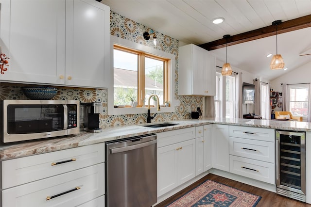 1127 Nadine St, Houston, TX 77009 - kitchen featuring wine cooler, stainless steel appliances, a sink, a peninsula, and decorative backsplash