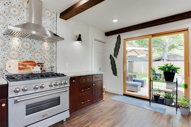 1127 Nadine St, Houston, TX 77009 - kitchen with high end stove, wall chimney exhaust hood, beam ceiling, light wood-style floors, and decorative backsplash