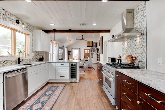 1127 Nadine St, Houston, TX 77009 - kitchen featuring stainless steel appliances, wall chimney exhaust hood, wine cooler, healthy amount of natural light, and recessed lighting