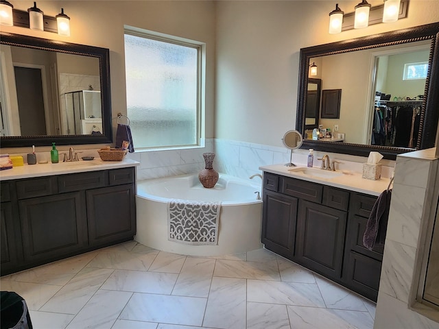 4723 Abercorn St, Rosharon, TX 77583 - bathroom featuring a stall shower, a bath, two vanities, and marble finish floors