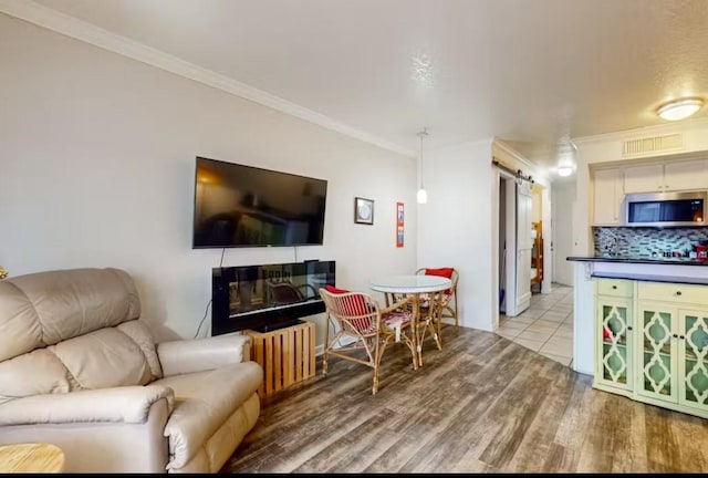 6300 Seawall Blvd Unit 3113, Galveston, TX 77551 - living room with a barn door, ornamental molding, and light wood finished floors