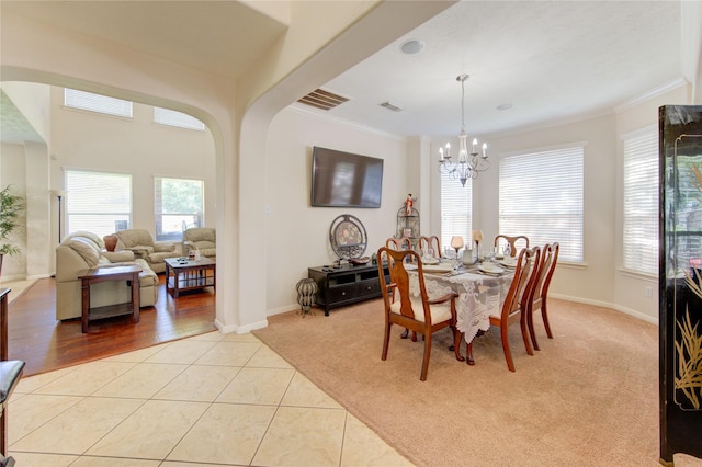 2127 Linden Rock Dr, Katy, TX 77494 - dining room with healthy amount of natural light, a chandelier, crown molding, light tile patterned flooring, and baseboards