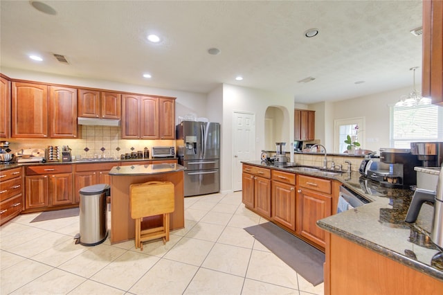 2127 Linden Rock Dr, Katy, TX 77494 - kitchen featuring stainless steel appliances, a sink, a kitchen island, under cabinet range hood, and a breakfast bar