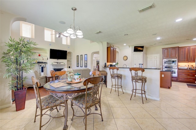 2127 Linden Rock Dr, Katy, TX 77494 - dining space featuring arched walkways, a chandelier, light tile patterned flooring, baseboards, and recessed lighting