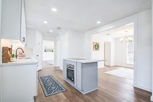 102 Banyan St, Lake Jackson, TX 77566 - kitchen with decorative backsplash, light wood-style floors, stainless steel oven, and recessed lighting