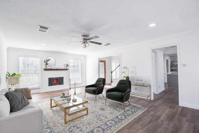 102 Banyan St, Lake Jackson, TX 77566 - living area featuring ornamental molding, a textured ceiling, wood finished floors, a ceiling fan, and a lit fireplace