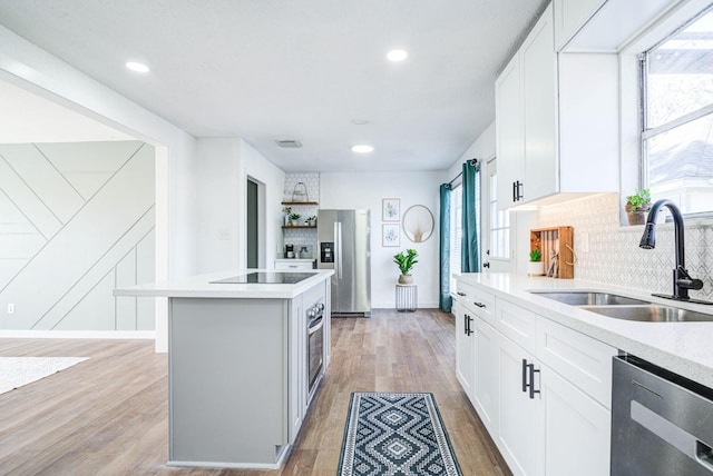102 Banyan St, Lake Jackson, TX 77566 - kitchen with appliances with stainless steel finishes, tasteful backsplash, light countertops, white cabinets, and recessed lighting