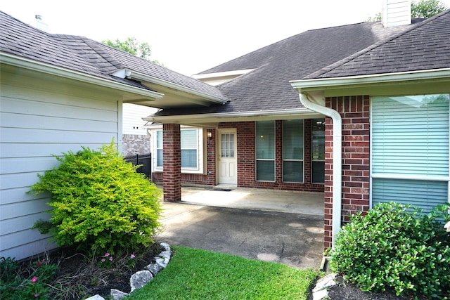 11714 Goldstream Ct, Tomball, TX 77377 - entrance to property featuring roof with shingles, a chimney, brick siding, and a patio