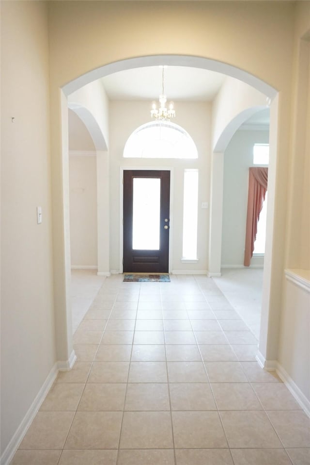 11714 Goldstream Ct, Tomball, TX 77377 - foyer featuring light tile patterned floors, arched walkways, and a chandelier