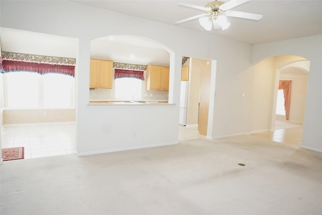 11714 Goldstream Ct, Tomball, TX 77377 - unfurnished living room featuring arched walkways, a ceiling fan, light colored carpet, and baseboards