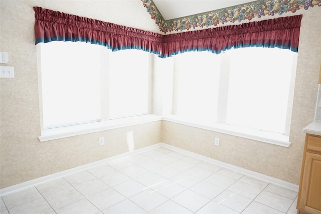 11714 Goldstream Ct, Tomball, TX 77377 - unfurnished dining area with lofted ceiling, baseboards, wallpapered walls, and light tile patterned flooring