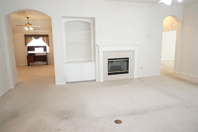 11714 Goldstream Ct, Tomball, TX 77377 - unfurnished living room featuring ceiling fan, carpet floors, built in shelves, and arched walkways
