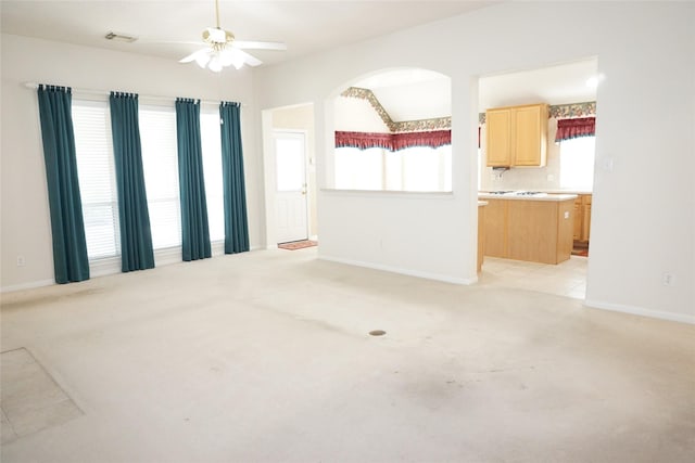 11714 Goldstream Ct, Tomball, TX 77377 - unfurnished living room with light colored carpet, ceiling fan, baseboards, and arched walkways