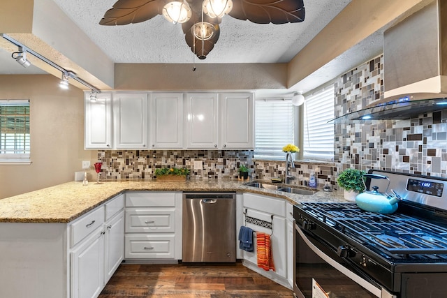 4302 Marchant Rd, Houston, TX 77047 - kitchen featuring appliances with stainless steel finishes, wall chimney range hood, a peninsula, healthy amount of natural light, and a textured ceiling