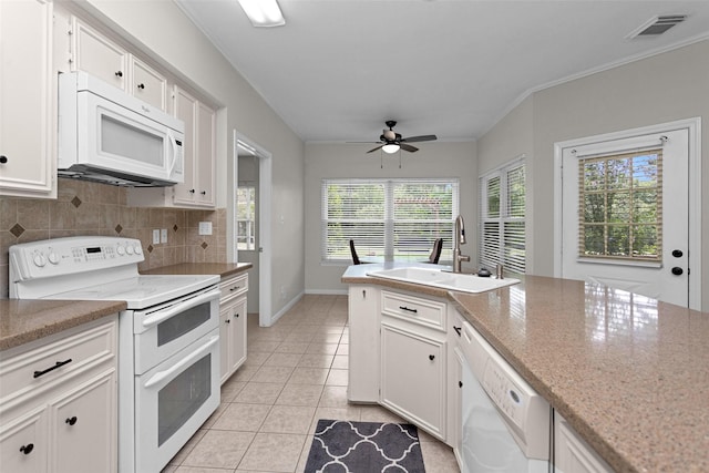 kitchen featuring white appliances, a sink, a ceiling fan, backsplash, and white cabinetry