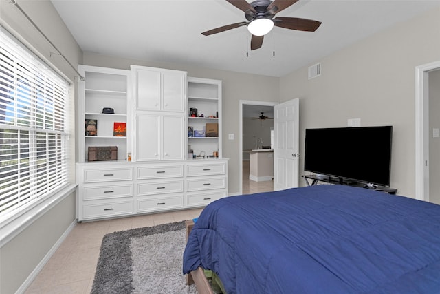 bedroom with light tile patterned floors, baseboards, a sink, and ceiling fan