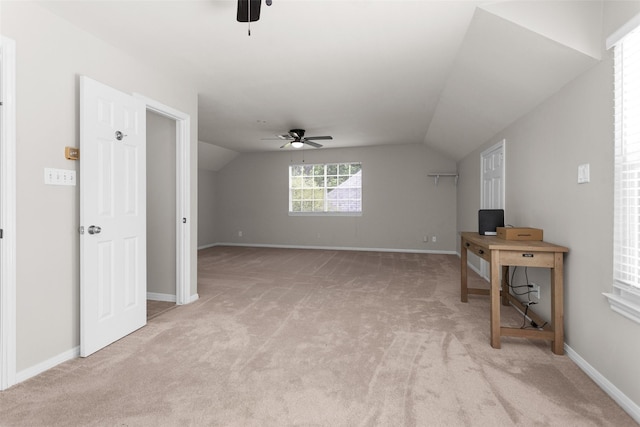 additional living space featuring a ceiling fan, light carpet, lofted ceiling, a desk, and baseboards
