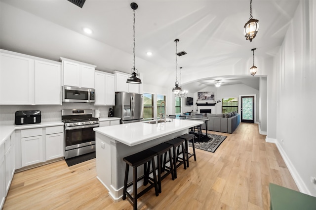 19266 Hazel Firs Ct, Magnolia, TX 77355 - kitchen featuring stainless steel appliances, vaulted ceiling, a center island with sink, a fireplace, and open floor plan