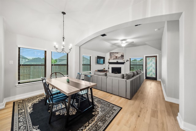 19266 Hazel Firs Ct, Magnolia, TX 77355 - dining area featuring lofted ceiling, a ceiling fan, a fireplace, a chandelier, and healthy amount of natural light