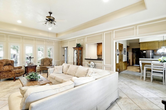 17714 Treeloch Ln, Spring, TX 77379 - living area with a decorative wall, a raised ceiling, ornamental molding, ceiling fan, and light tile patterned floors