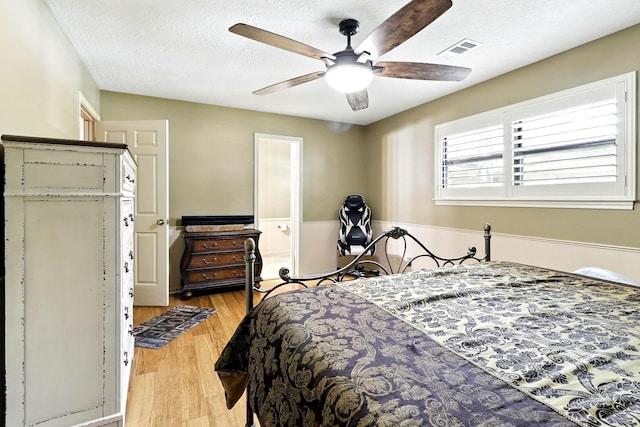 17714 Treeloch Ln, Spring, TX 77379 - bedroom with light wood-style flooring, a textured ceiling, ceiling fan, and connected bathroom