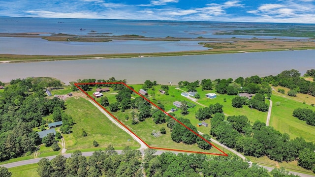 3428 S Main St, Anahuac, TX 77514 - aerial view of property and surrounding area featuring a large body of water, property boundaries highlighted, and a tree filled landscape