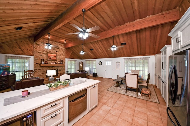 3428 S Main St, Anahuac, TX 77514 - kitchen featuring black appliances, open floor plan, light tile patterned floors, white cabinetry, and wood walls
