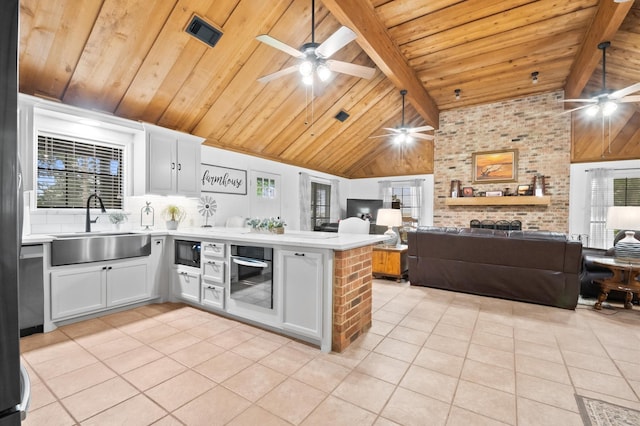 3428 S Main St, Anahuac, TX 77514 - kitchen with a ceiling fan, a peninsula, stainless steel oven, a sink, and wood ceiling with exposed beams