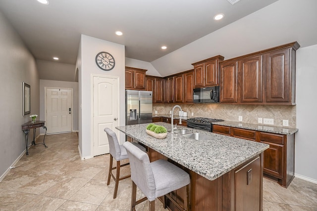10911 Overland Trail Dr, Richmond, TX 77406 - kitchen featuring appliances with stainless steel finishes, a sink, light stone countertops, a breakfast bar, and vaulted ceiling