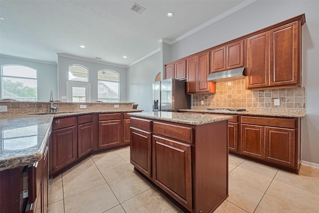 13903 Autumn Grove Ct, Rosharon, TX 77583 - kitchen featuring under cabinet range hood, appliances with stainless steel finishes, a sink, ornamental molding, and light tile patterned flooring