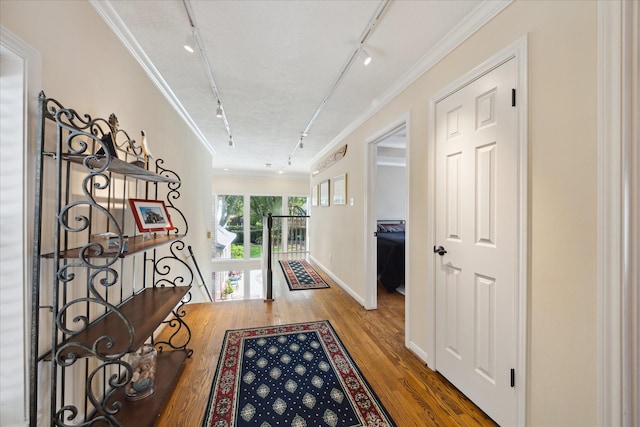 311 Pineview Cir, El Lago, TX 77586 - hall featuring rail lighting, ornamental molding, wood finished floors, and baseboards