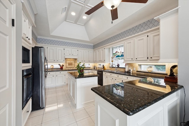 311 Pineview Cir, El Lago, TX 77586 - kitchen with black appliances, a sink, a peninsula, light tile patterned flooring, and a tray ceiling